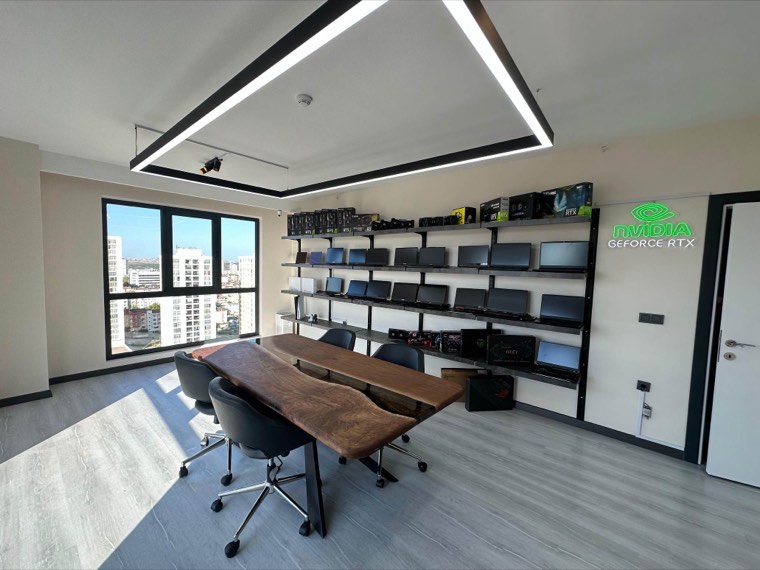 Showroom duvarındaki raflarda sıralanmış notebook ve ekran kartı stoğu